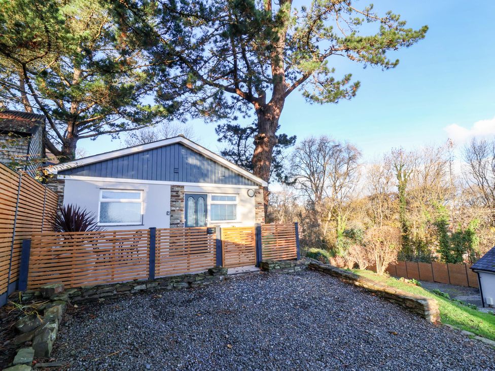 A house with a wooden fence and gravel area at Tarka View in Bideford