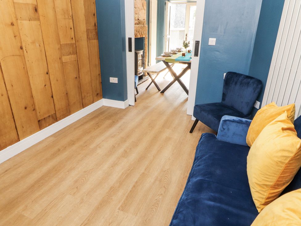A living room with a wooden wall and furniture at 10 Keekle Terrace in Cleator Moor
