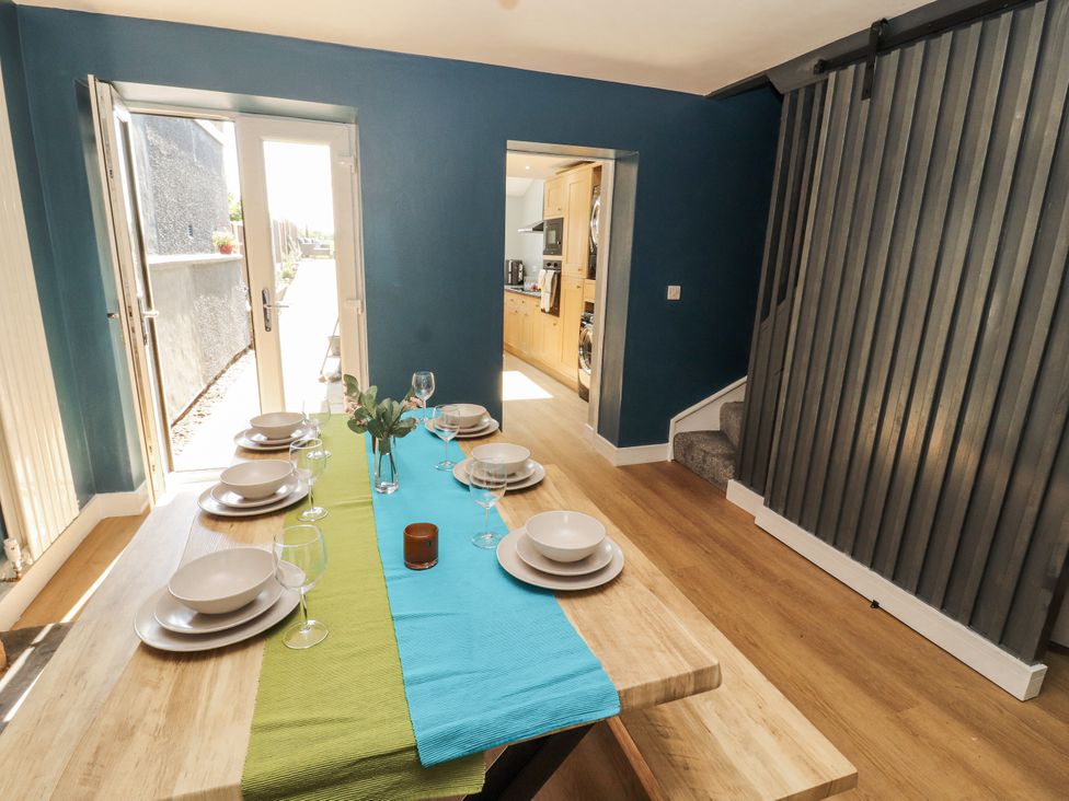 A dining room with a table set for meals at 10 Keekle Terrace in Cleator Moor