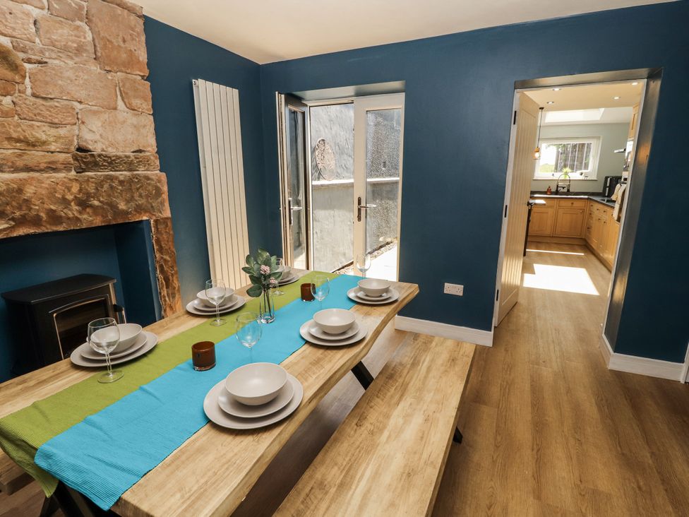 A dining room with a table set for a meal at 10 Keekle Terrace in Cleator Moor