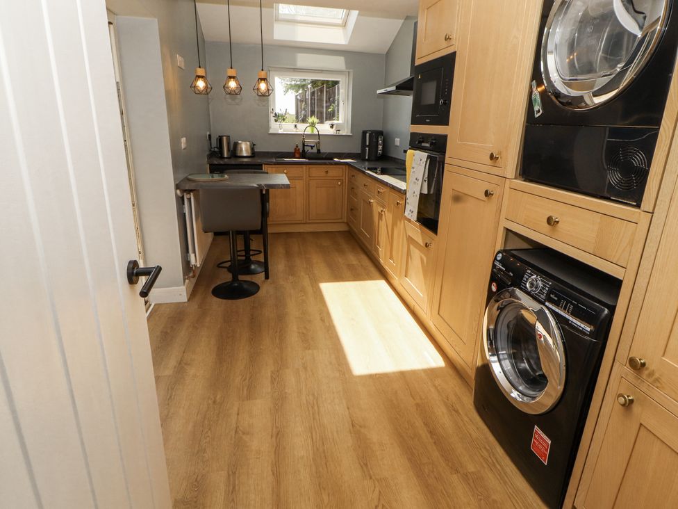A kitchen with wooden cabinets and appliances at 10 Keekle Terrace Cleator Moor