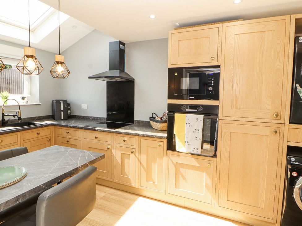 A kitchen with cabinets and appliances at 10 Keekle Terrace in Cleator Moor