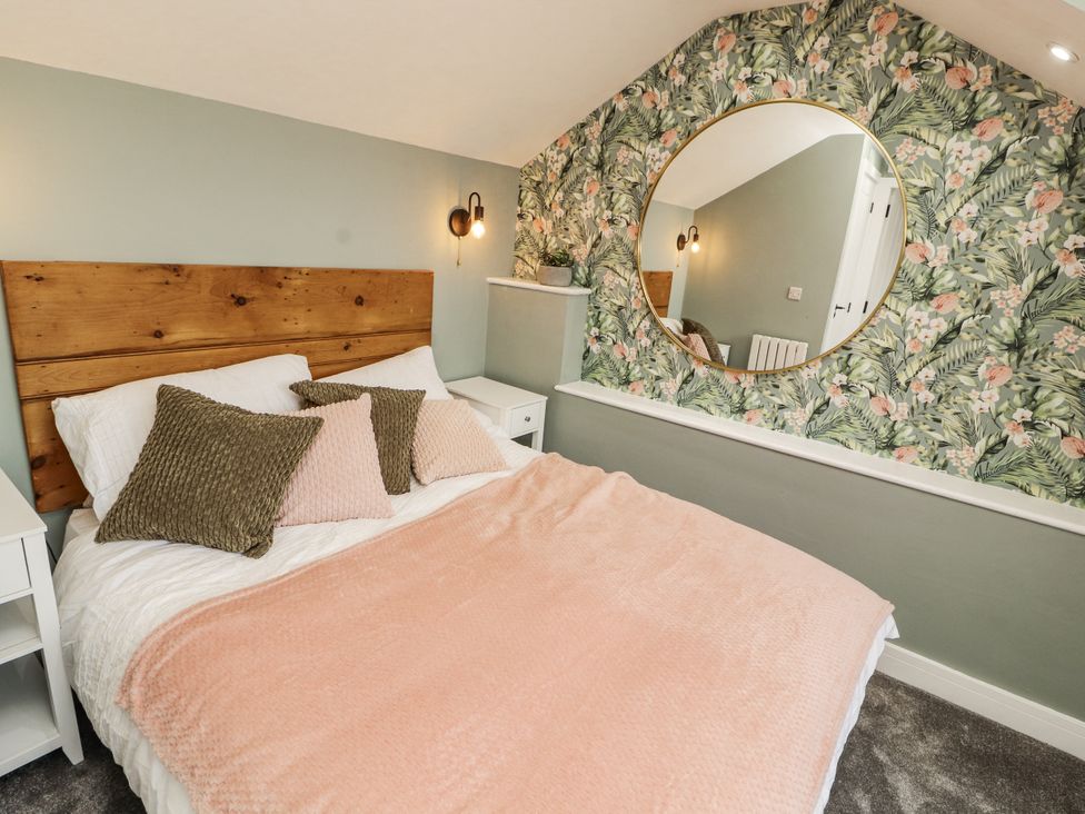 A bedroom with a bed and mirror at 10 Keekle Terrace in Cleator Moor