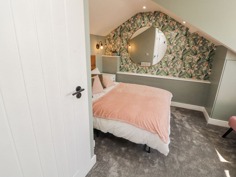 A bedroom with a bed and decorative wall at 10 Keekle Terrace in Cleator Moor