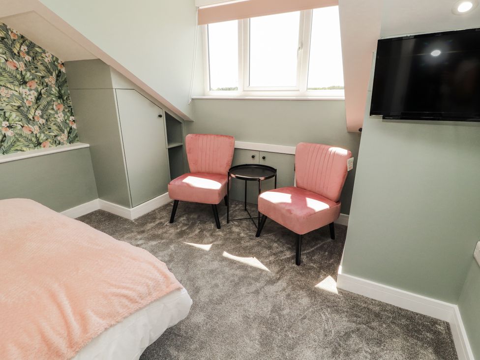 A bedroom with a bed and chairs at 10 Keekle Terrace in Cleator Moor