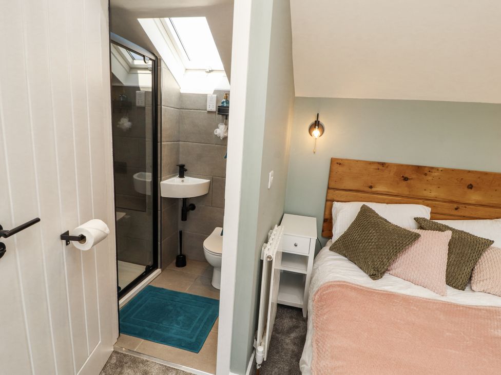 A bedroom with a bed and a bathroom in the background at 10 Keekle Terrace Cleator Moor