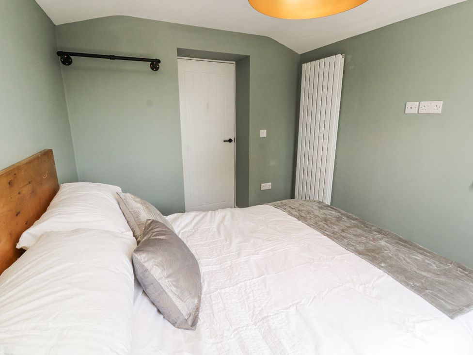 A bedroom with a bed and a door at 10 Keekle Terrace in Cleator Moor