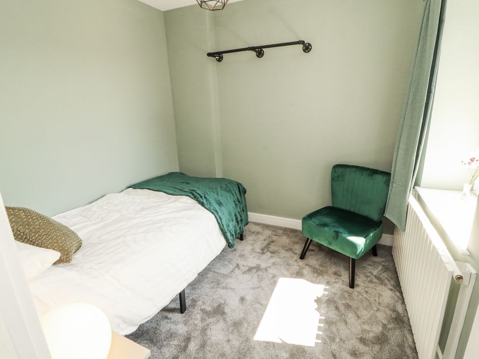 A bedroom with a bed and chair at 10 Keekle Terrace in Cleator Moor