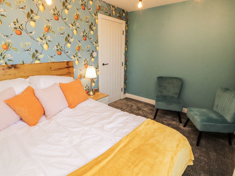 A bedroom with a bed and two chairs at 10 Keekle Terrace in Cleator Moor