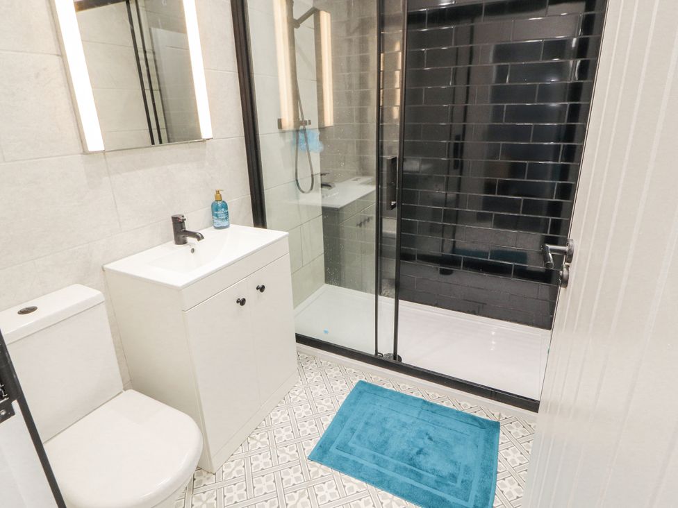 A bathroom with a shower and sink at 10 Keekle Terrace in Cleator Moor