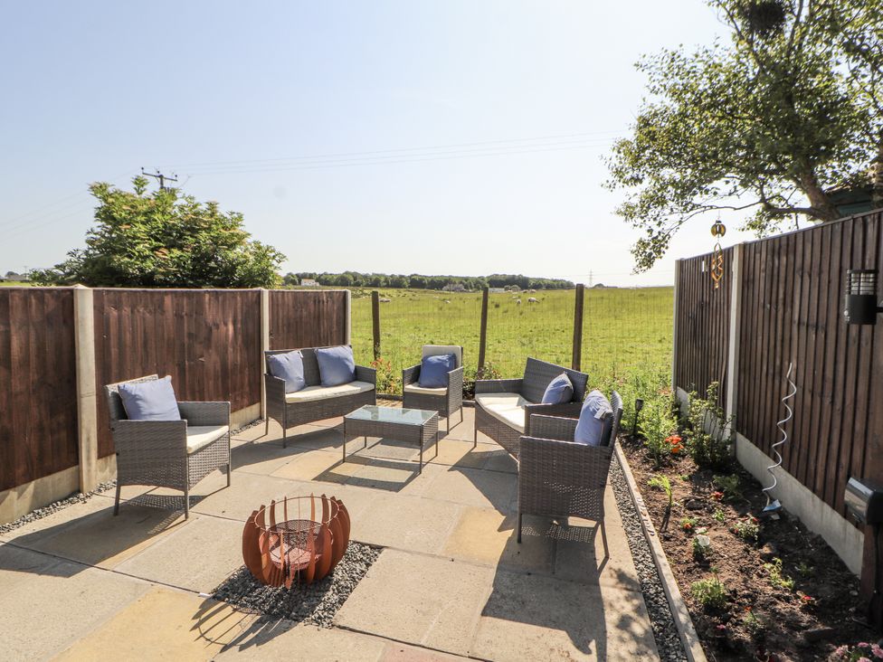 An outdoor seating area with chairs and a table at 10 Keekle Terrace in Cleator Moor