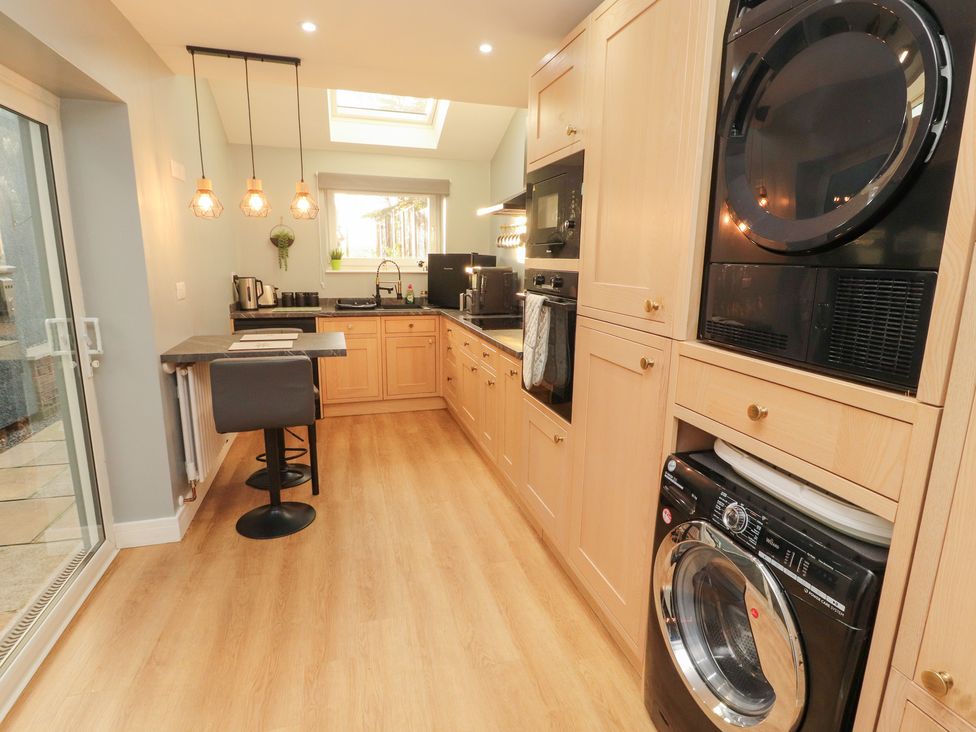 A kitchen with appliances and dining area at 10 Keekle Terrace in Keekle near Cleator Moor