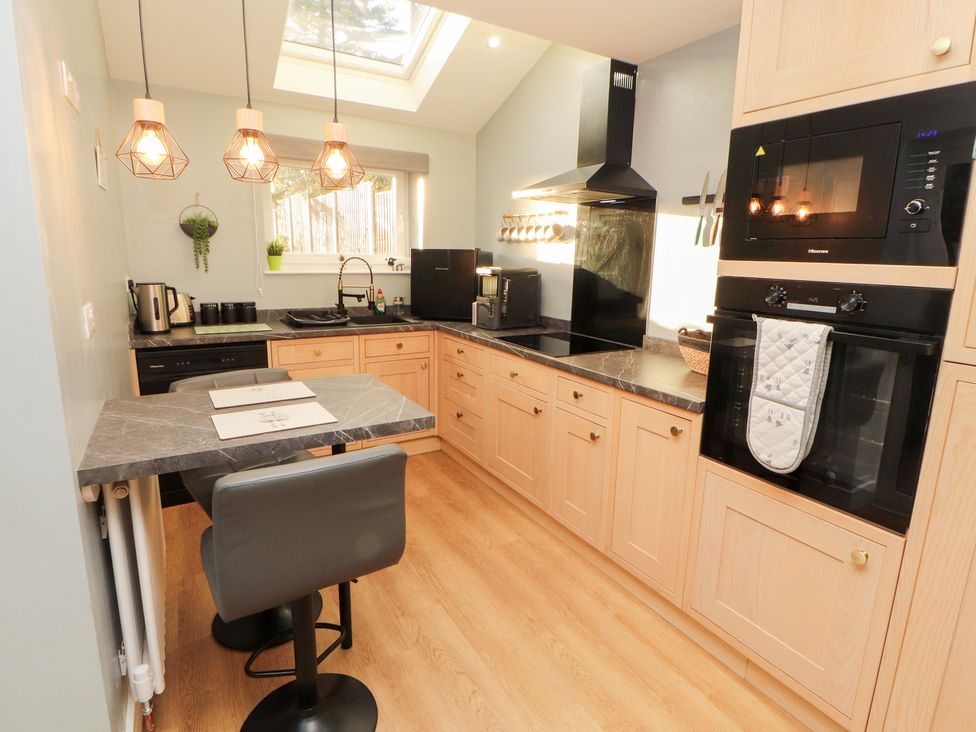 A kitchen with modern appliances and a table at 10 Keekle Terrace in Keekle near Cleator Moor