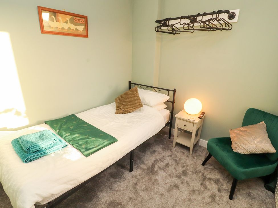 A bedroom with a bed and a chair at 10 Keekle Terrace in Keekle near Cleator Moor