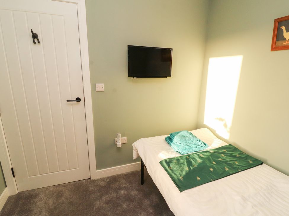 A bedroom with a bed and television at 10 Keekle Terrace in Keekle near Cleator Moor