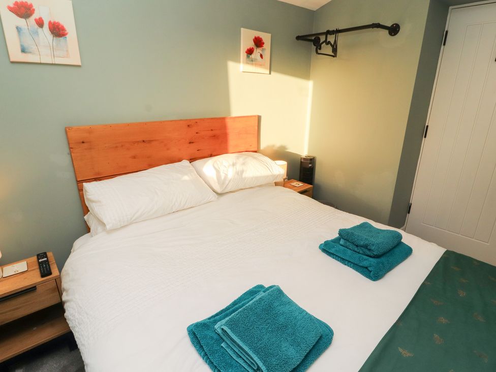 A bedroom with a bed and towels on top at 10 Keekle Terrace in Keekle near Cleator Moor