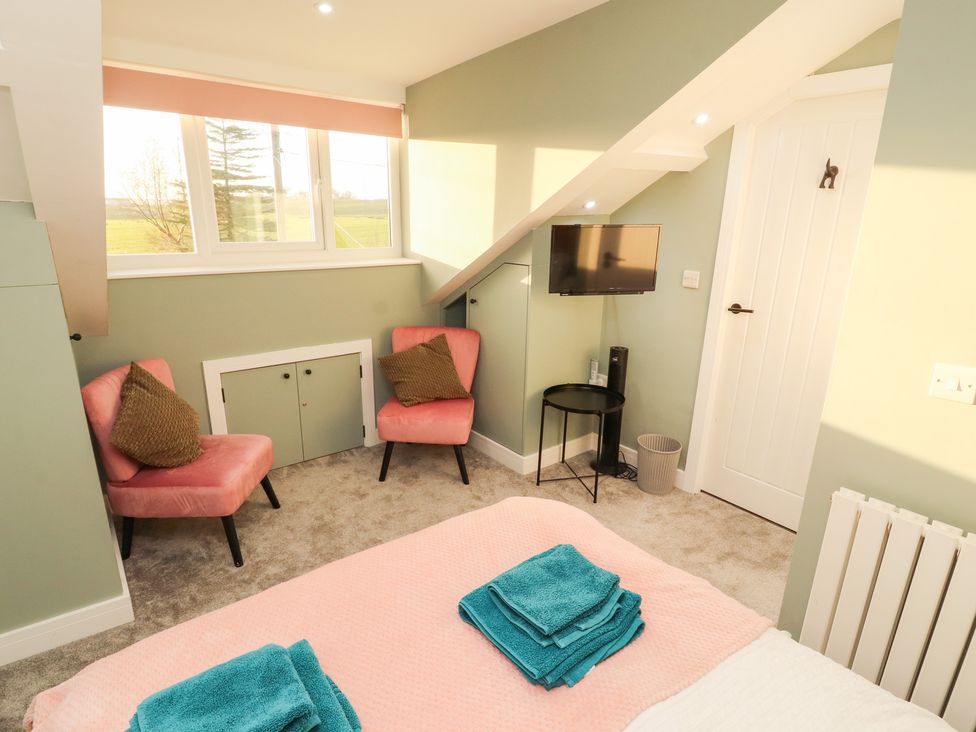 A bedroom with a bed and two chairs at 10 Keekle Terrace in Keekle near Cleator Moor