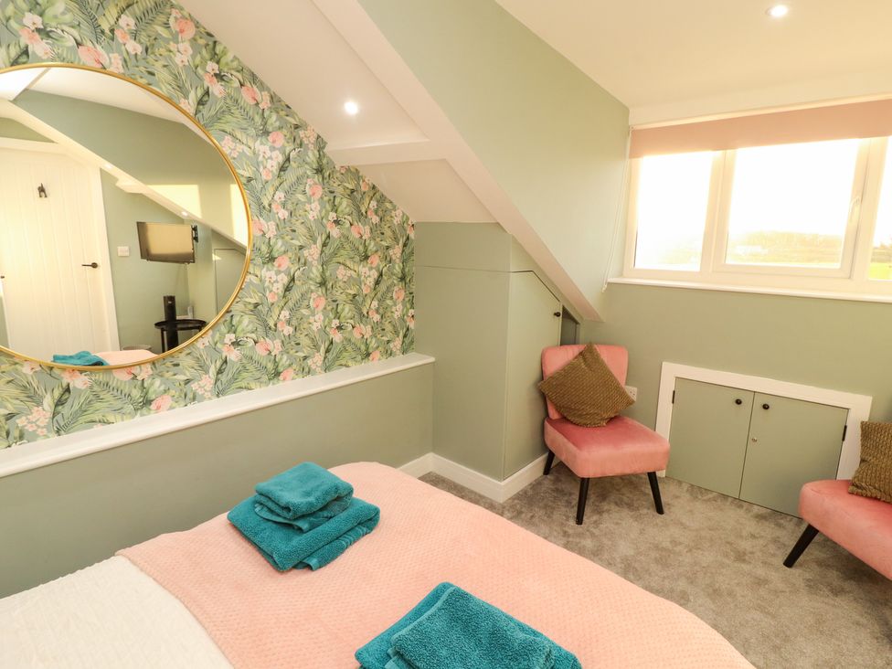 A bedroom with a bed and chairs at 10 Keekle Terrace in Keekle near Cleator Moor