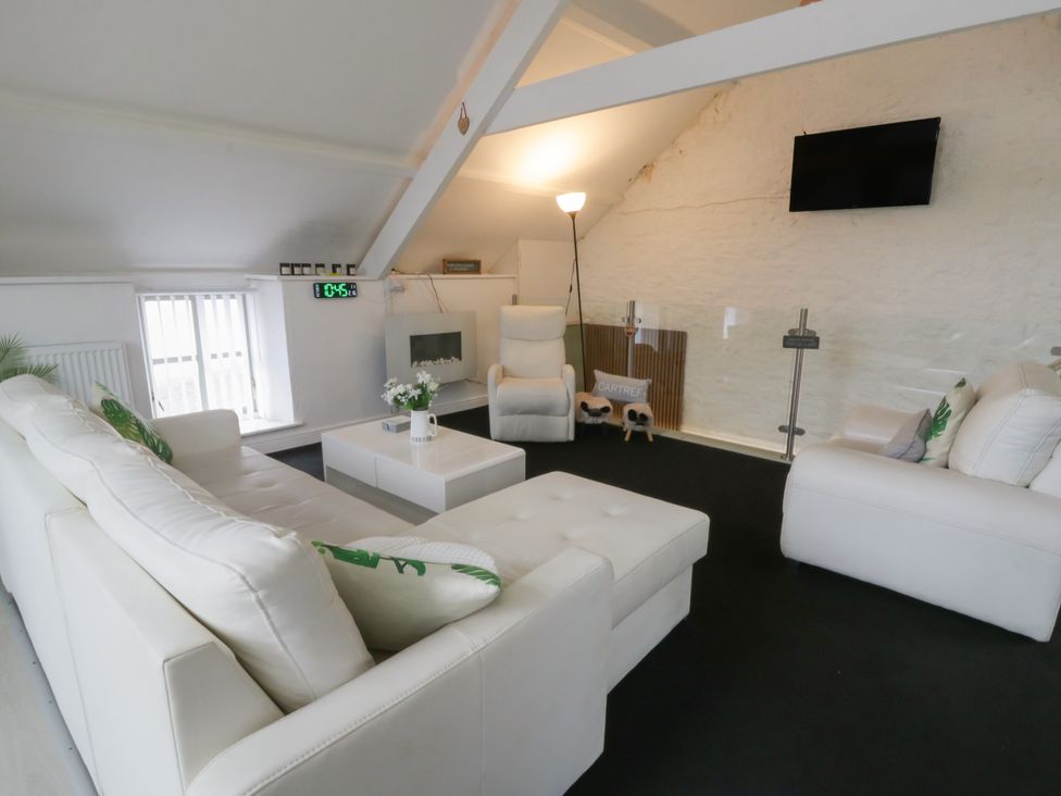 A living room with a sofa and armchair at The Old Workshop in Dre-Fach near Lampeter