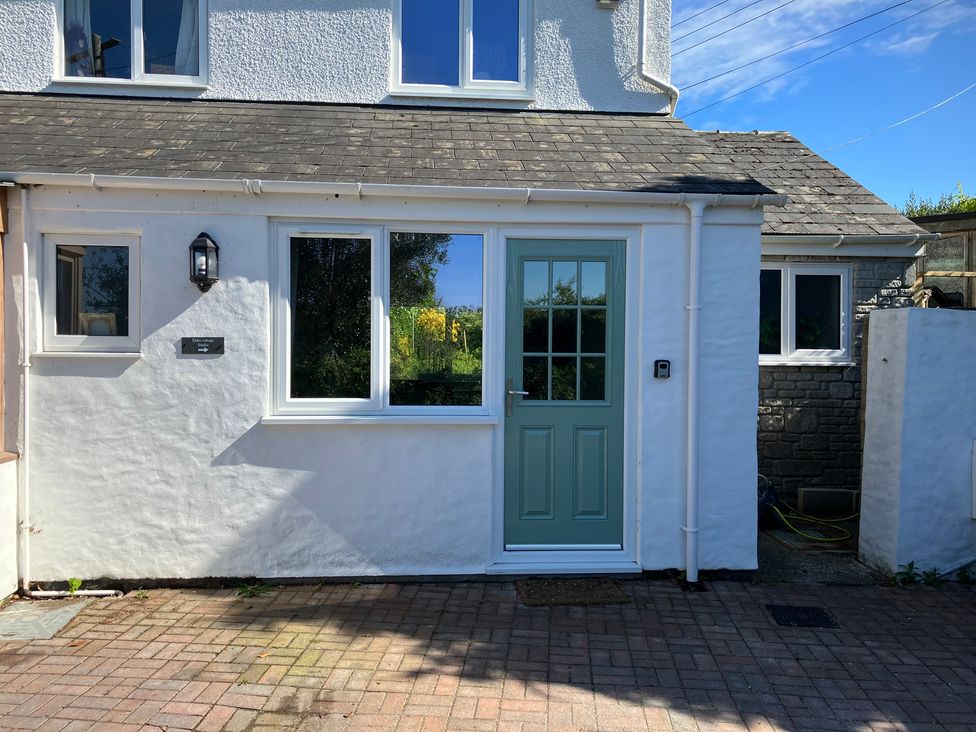 An exterior view of a house with a blue door and windows at Elder Cottage Studio Perranwell Station near Ponsanooth