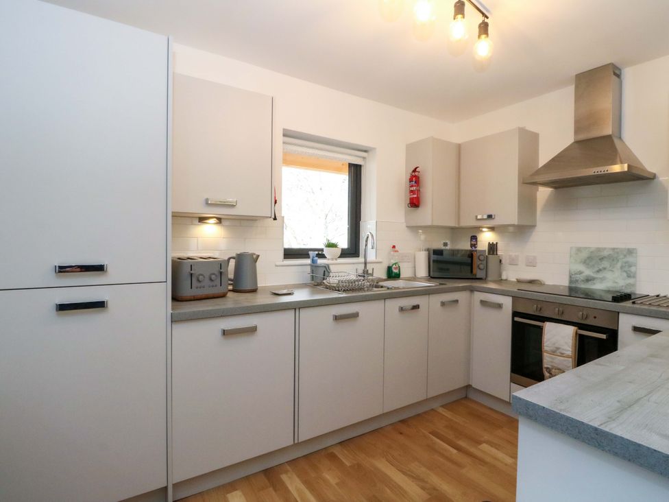 A kitchen with cabinets, sink, microwave, and stove at 25 Strathtay Lodges in Aberfeldy