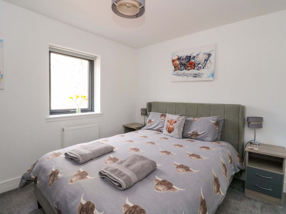 A bedroom with a bed and bedside tables at 25 Strathtay Lodges in Aberfeldy
