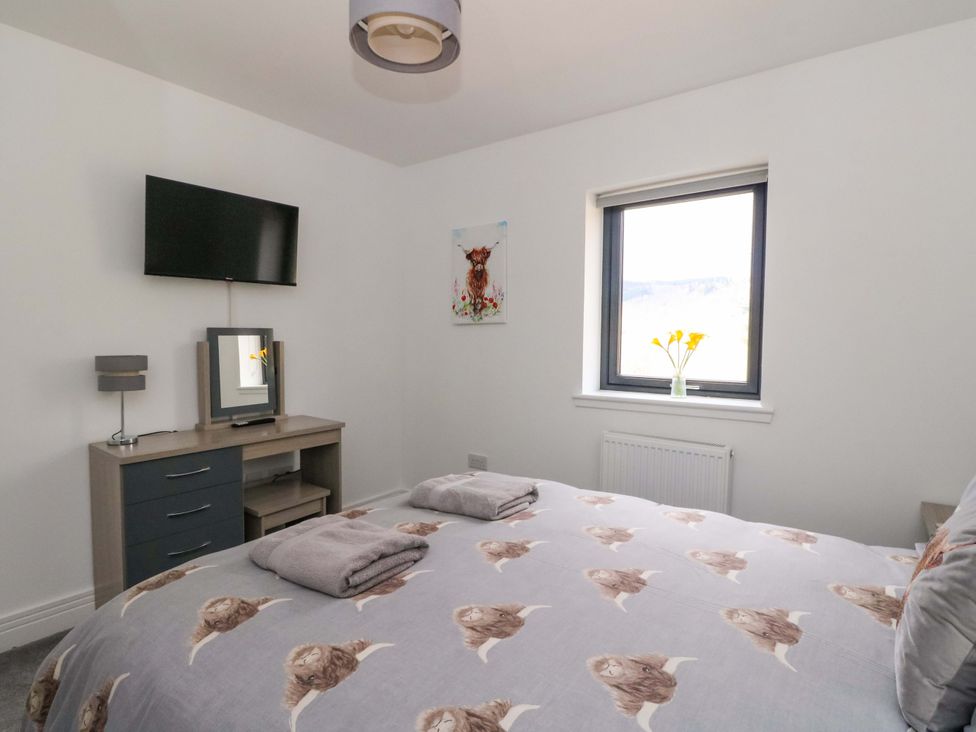 A bedroom with a bed and television at 25 Strathtay Lodges in Aberfeldy