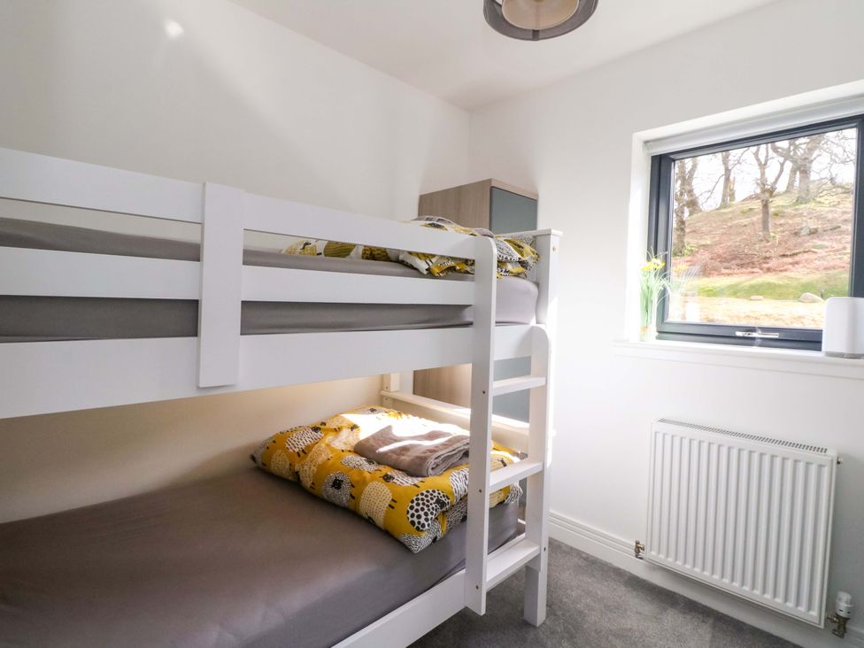 A bedroom with a bunk bed and a window at 25 Strathtay Lodges Aberfeldy