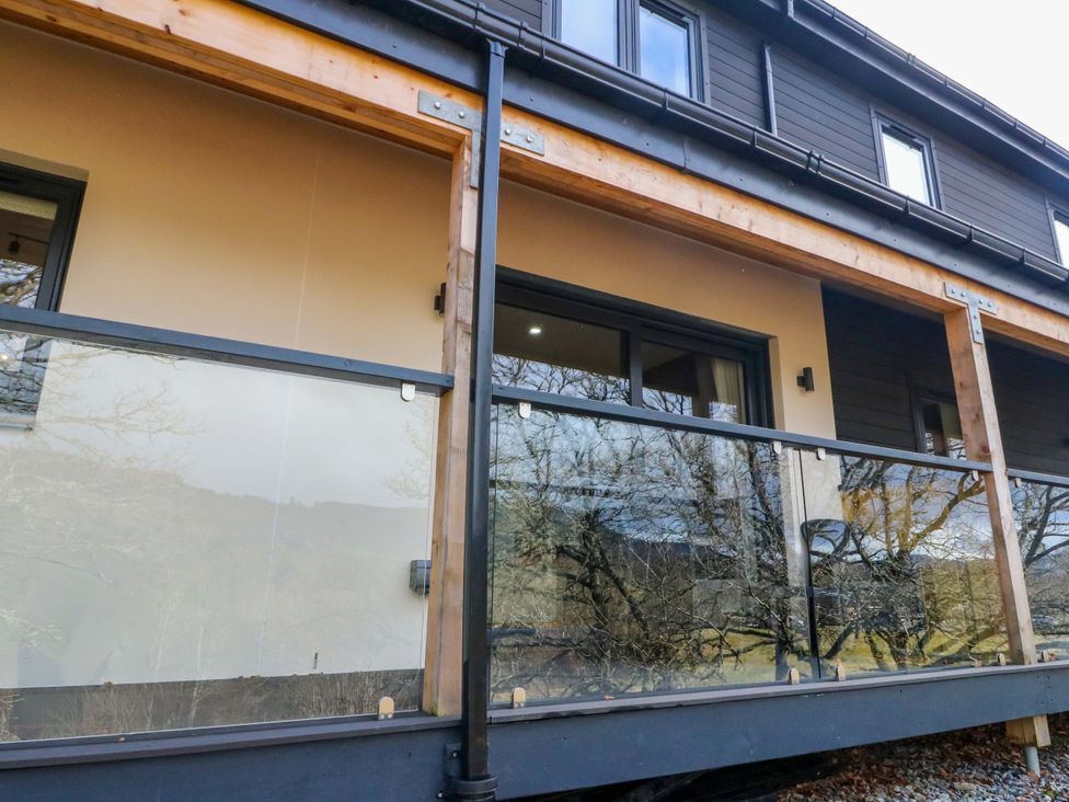 An outdoor view of a building with a balcony and glass railing at 25 Strathtay Lodges Aberfeldy