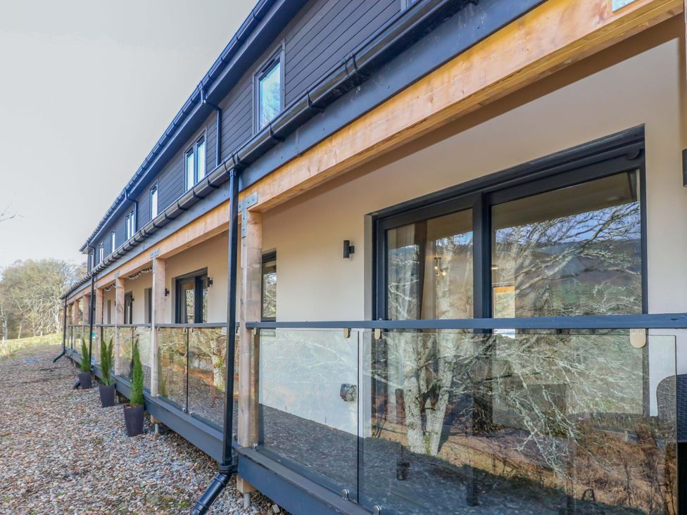 A balcony with glass railing and windows at 25 Strathtay Lodges in Aberfeldy