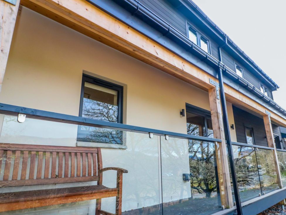 An outdoor balcony with a bench in front at 25 Strathtay Lodges Aberfeldy