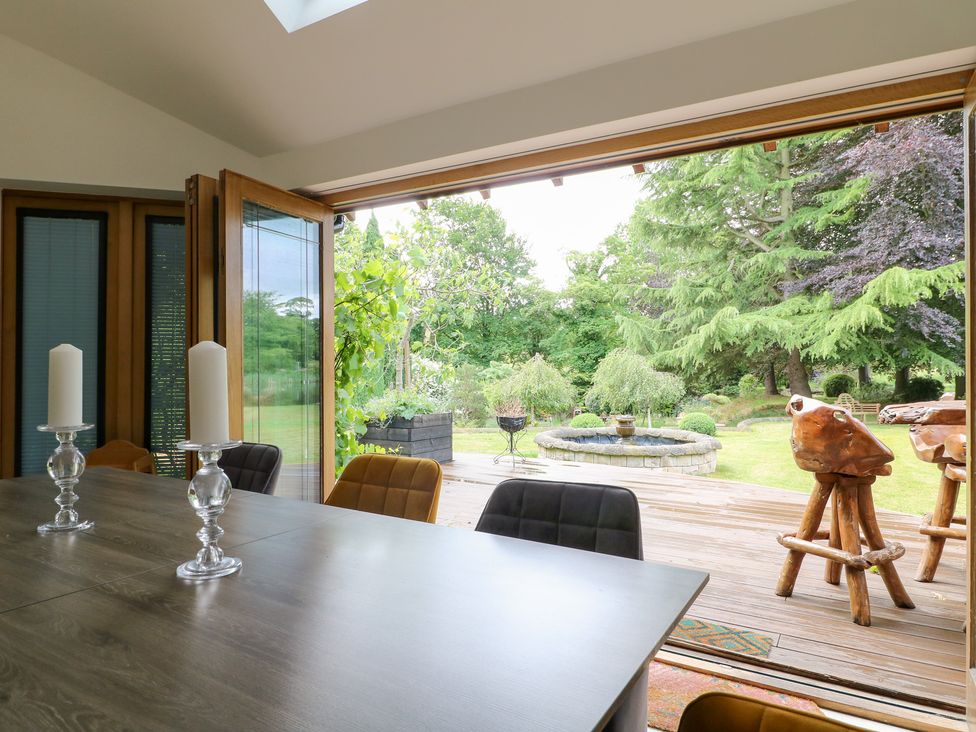 A dining room with a view of the garden at Old Mill House in Cuckney