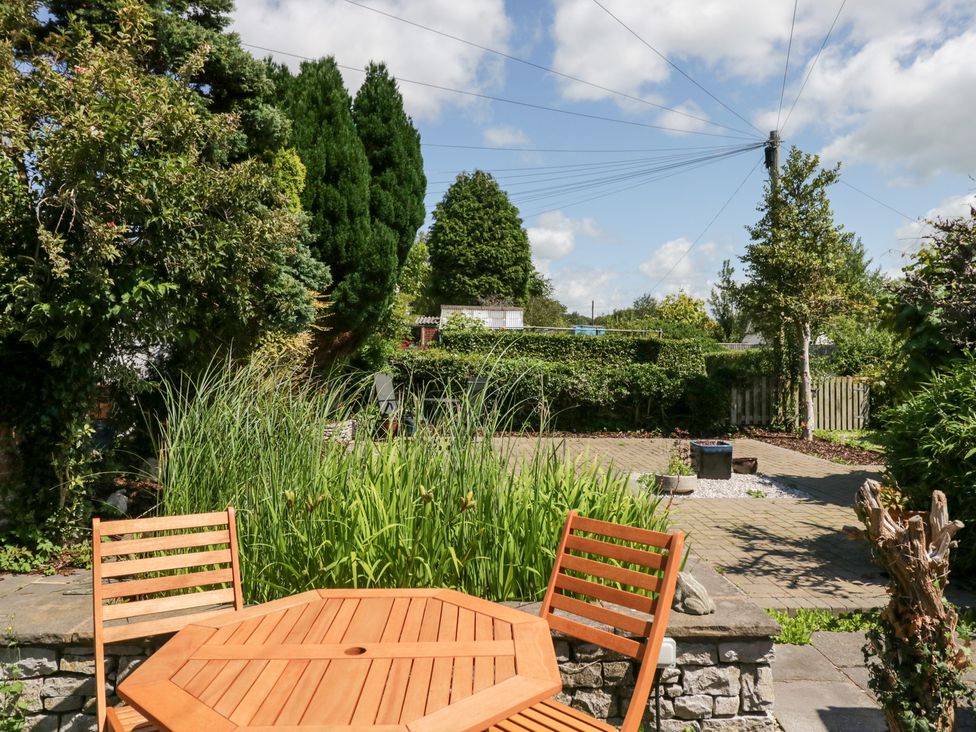 A garden with a table and chairs at Timekeeper's Cottage in Warton near Carnforth