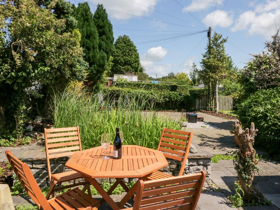 A garden with a table and chairs at Timekeeper's Cottage in Warton near Carnforth