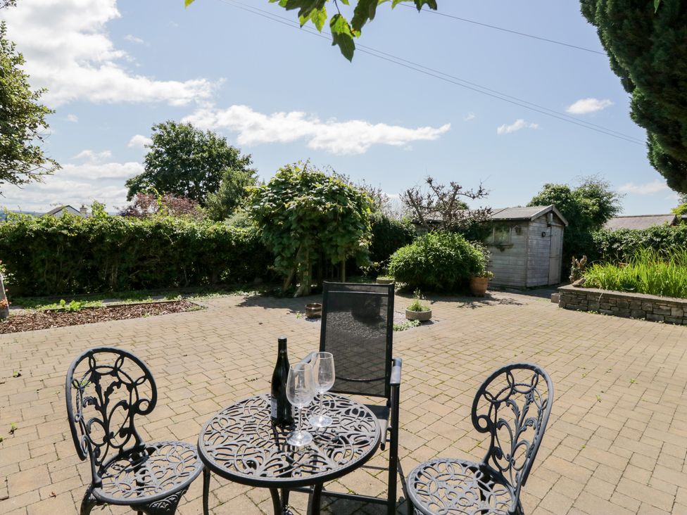 A garden with a table and chairs at Timekeeper's Cottage Warton near Carnforth