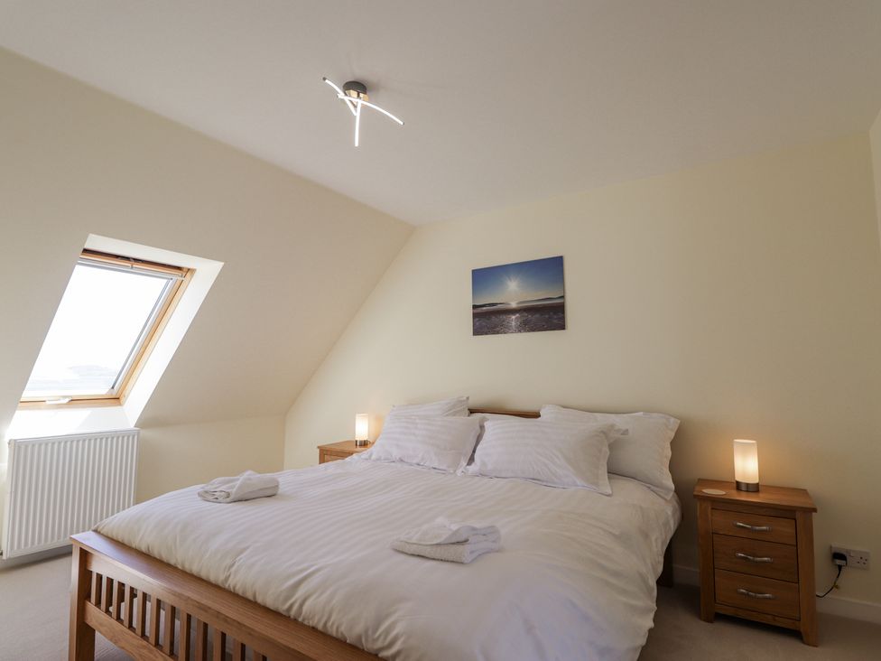 A bedroom with a double bed and bedside tables with lamps at Calmdale in Inverasdale near Poolewe