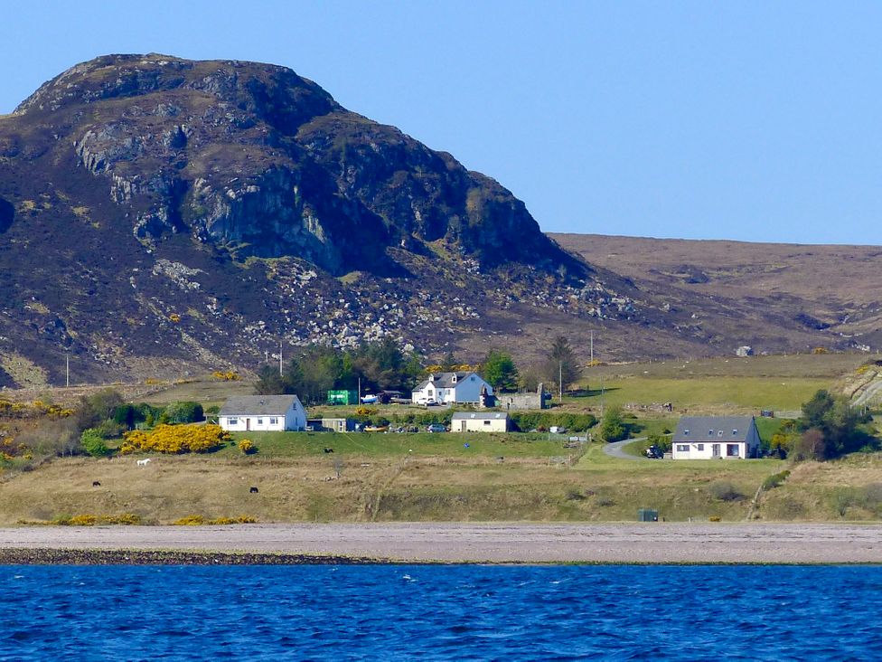 A small cluster of houses near a hill by the sea at Calmdale in Inverasdale near Poolewe