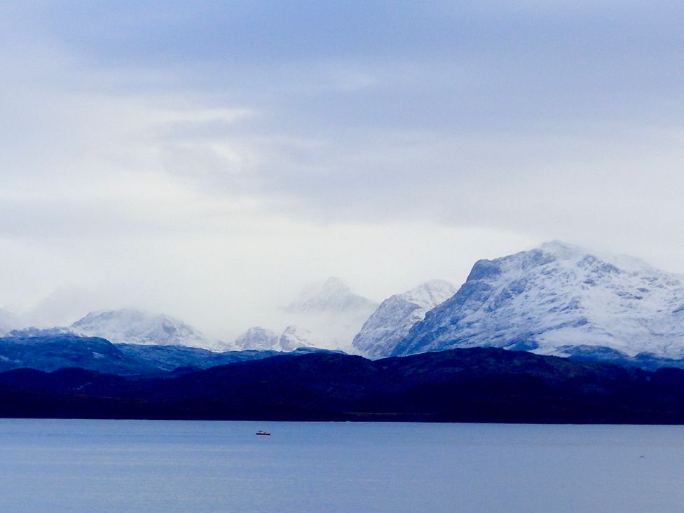 A large body of water with snow-covered mountains in the background at Calmdale Inverasdale near Poolewe