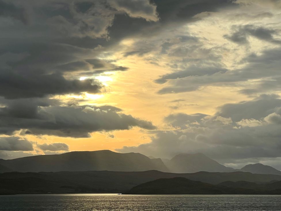 A body of water with hills and clouds at Calmdale in Inverasdale near Poolewe