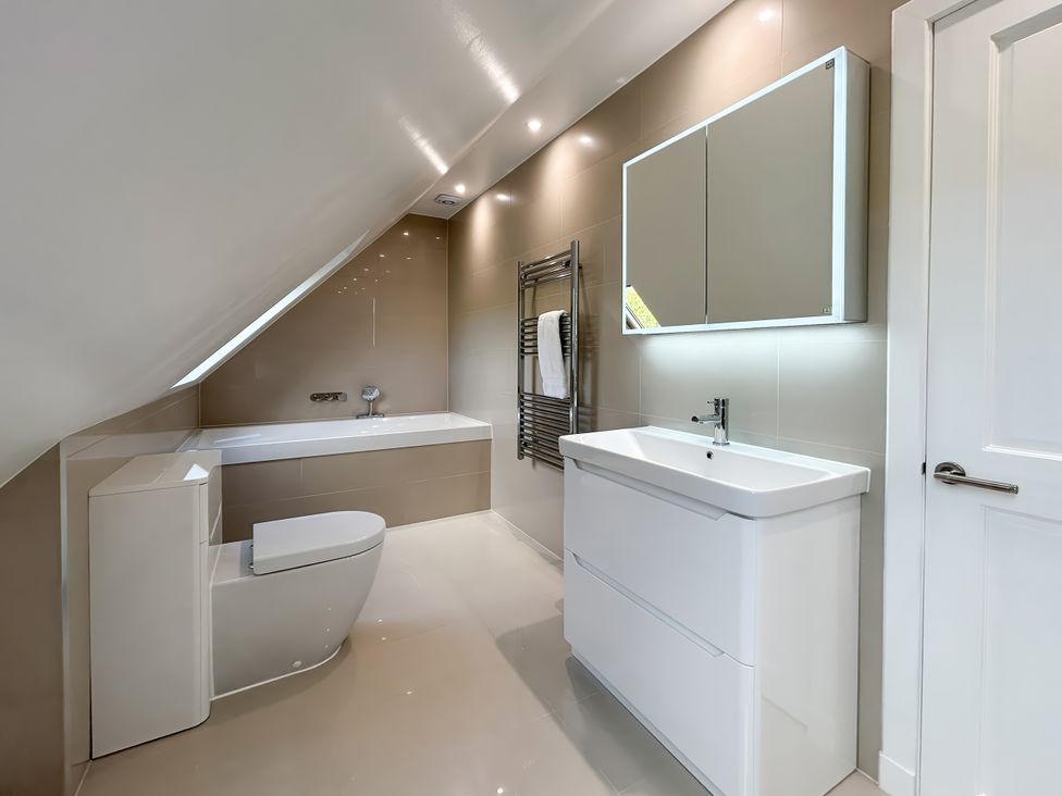 A bathroom with a bathtub, toilet, and sink at Calmdale in Inverasdale near Poolewe