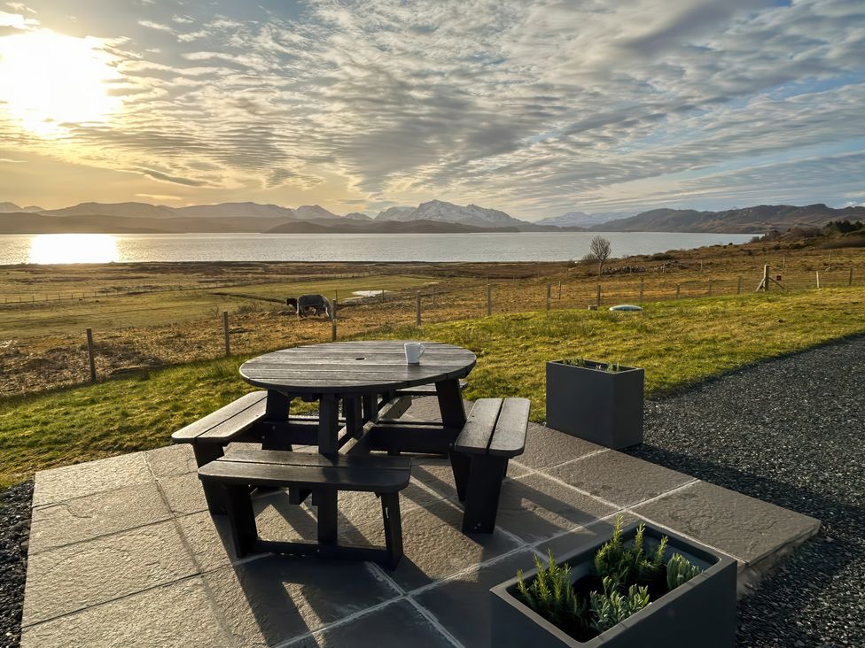 A picnic table and planter overlooking a lake at Calmdale in Inverasdale near Poolewe