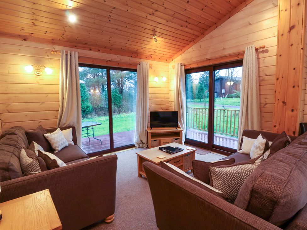 A living room with a sofa and a television at Elderberrys Lodge in Bideford