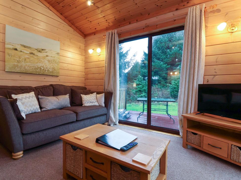 A living room with a sofa and television at Elderberrys Lodge in Bideford