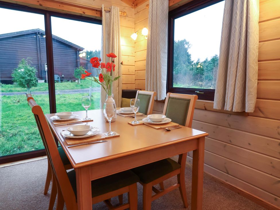 A dining room with a table set for meals at Elderberrys Lodge in Bideford
