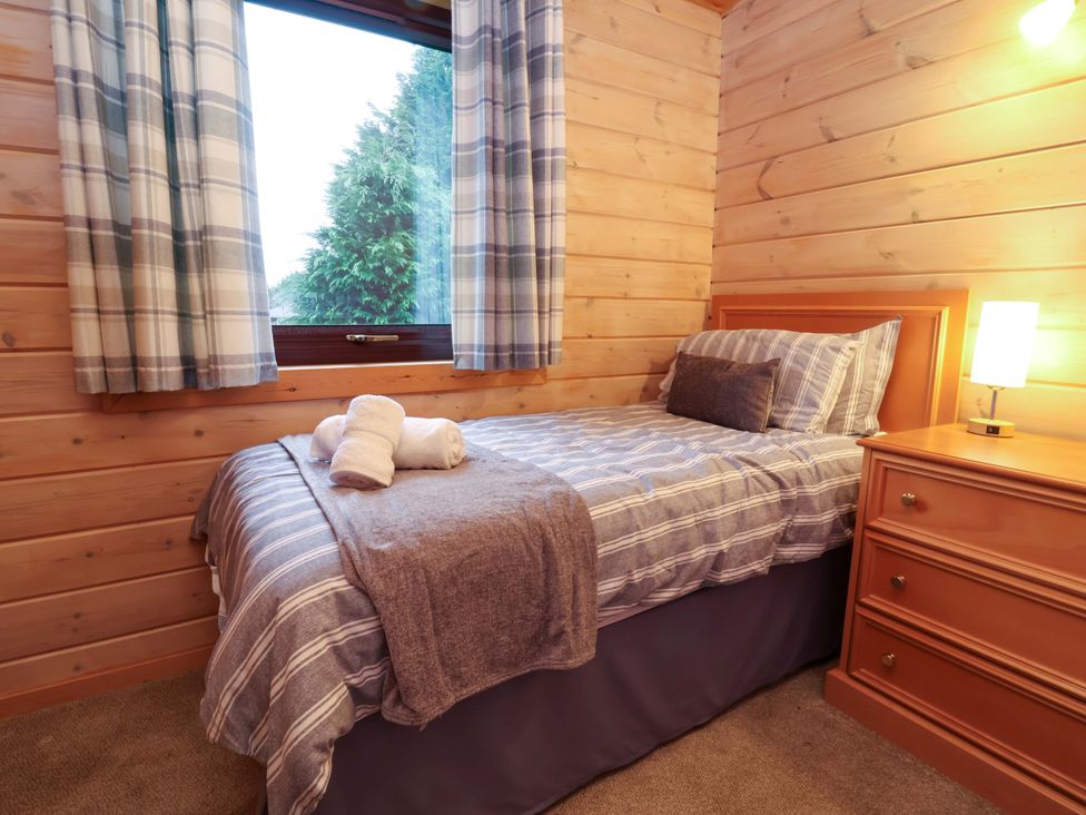 A bedroom with a bed and lamp at Elderberrys Lodge in Bideford