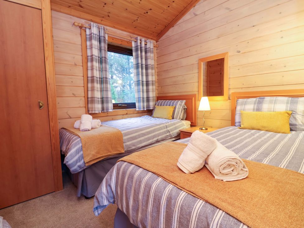 A bedroom with two beds and a lamp at Elderberrys Lodge in Bideford