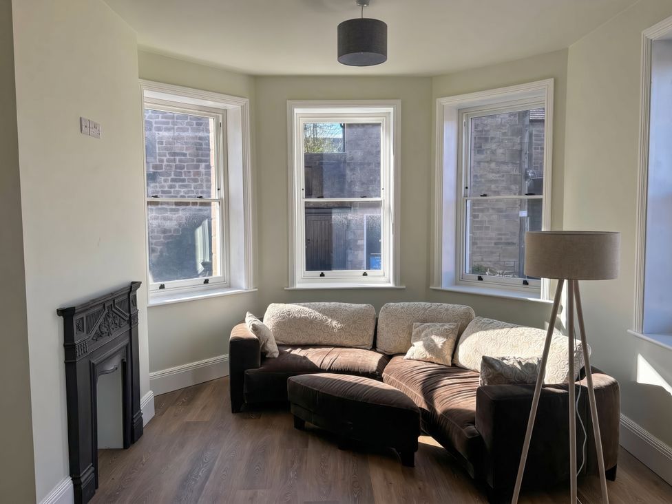 A living room with a sofa and a lamp at Holt Hall - Ground Floor Apartment in Matlock