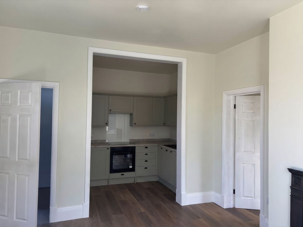 A kitchen with cabinets and an oven at Holt Hall - Ground Floor Apartment in Matlock