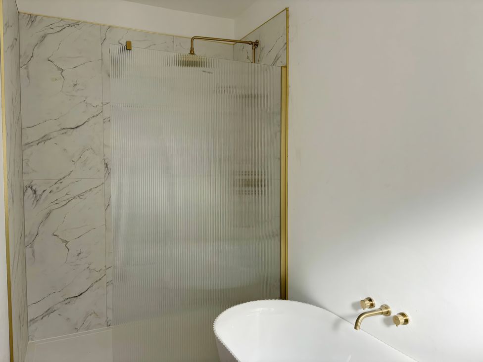 A bathroom with a shower and bathtub at Holt Hall - Ground Floor Apartment Matlock