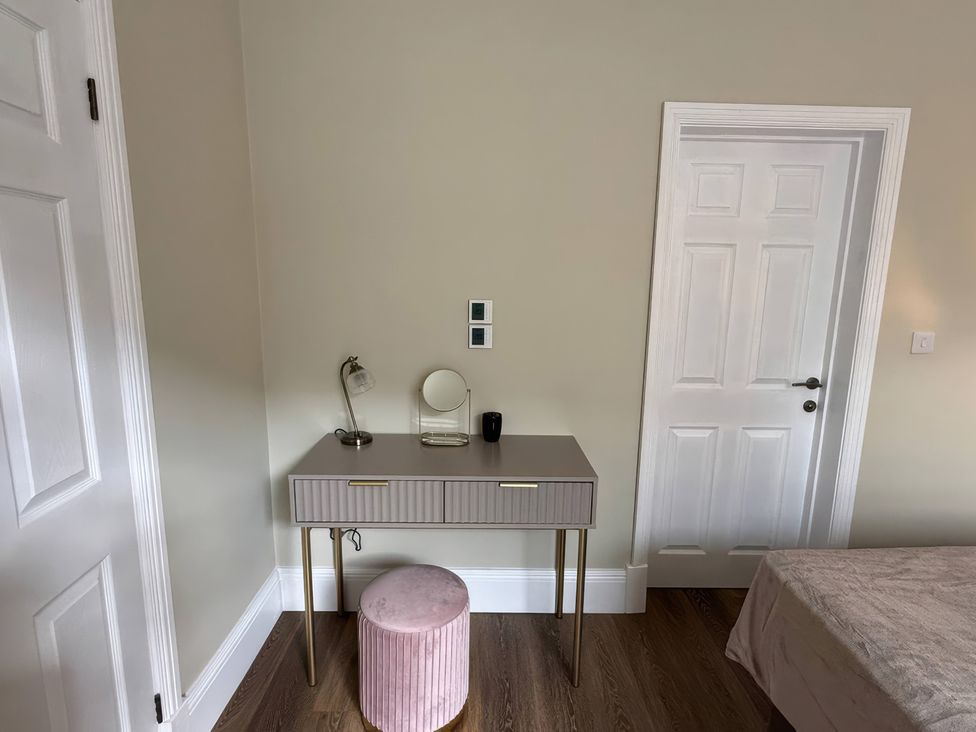 A bedroom with a desk and stool at Holt Hall - Ground Floor Apartment in Matlock